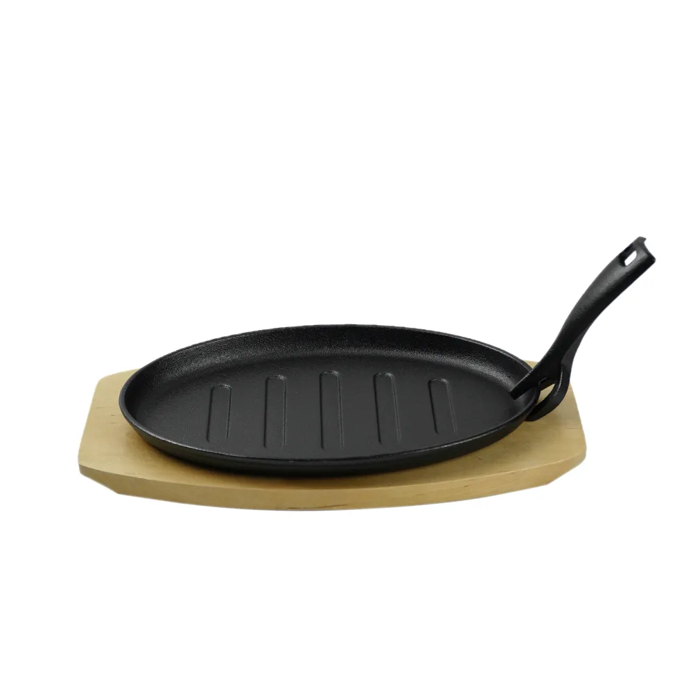 The cast-iron steak plate and oval-shaped frying pan with a wooden base are suitable for kitchens and dining rooms